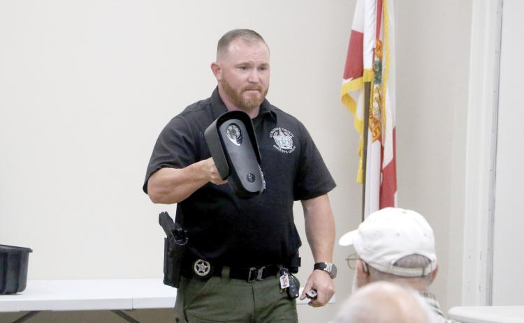 Suwannee County Sheriff’s Office Investigator Jacob Williamson shows nearly 30 people at the Suwannee River Regional Library’s Live Oak branch a Flock camera during Monday’s community meeting. (MORGAN MCMULLEN/Lake City Reporter)