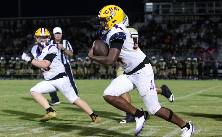 Columbia defensive end Jae’Quan Wilson races toward the end zone after scooping up an Oakleaf fumble Friday night while linebacker Bryson Grinstead looks on. Wilson scored on the play. (GARY LLOYD MCCULLOUGH/Special to the Reporter)