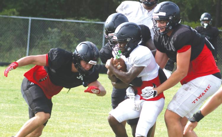 Fort White linebacker Kayden Ireland (left) and defensive lineman Cillian Sheehan (right) wrap up running back Jeremiah Taylor during Monday’s practice. (MORGAN MCMULLEN/Lake City Reporter)