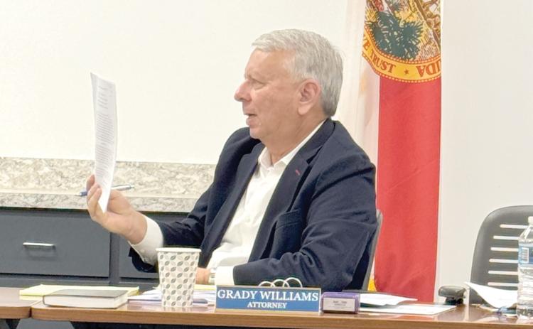 North Florida Water Utilities Authority Attorney Grady Williams holds up a copy of the 2025 interlocal agreement between the authority and both Columbia and Suwannee counties about operation and transfer of the utility assets in both counties. (JAMIE WACHTER/Lake City Reporter)