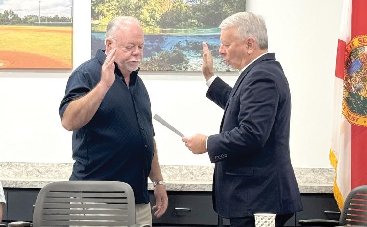 North Florida Utilities Authority board member Jock Phelps (left) is sworn in ahead of Monday’s meeting by NFWUA Attorney Grady Williams. Monday was Phelps’ first meeting as a member of the utility board. (JAMIE WACHTER/Lake City Reporter)