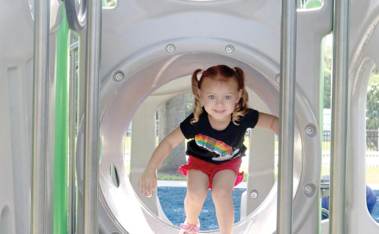 Ellie Davis makes her way through a tunnel on a piece of equipment at Sallie Mae Jerry Park on Friday. (TONY BRITT/Lake City Reporter)