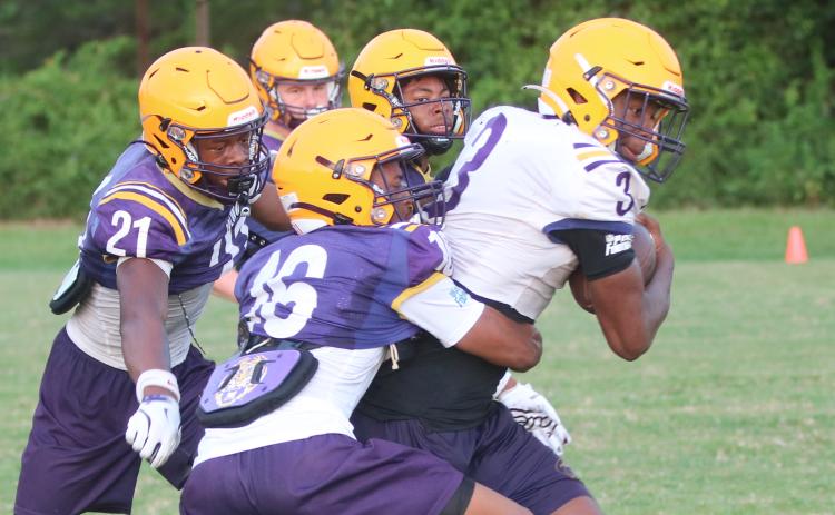 Columbia receiver Zion Walker fights to break away from a tackle from defensive back Mekah Combs-Turner (16) as defensive backs Jermone Carter (21) and Chris Austin (back) give chase during Wednesday’s practice. (JORDAN KROEGER/Lake City Reporter)