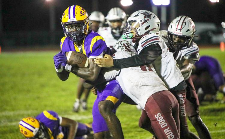 Columbia receiver Kyren Caldwell fights for extra yardage as he’s tackled by a group of Madison County defenders following a catch last Friday. (BRENT KUYKENDALL/Lake City Reporter)