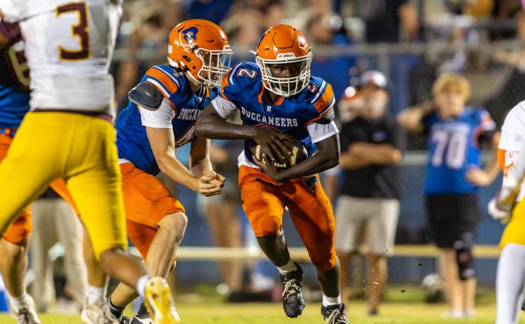 Branford quarterback Trent Land hands the ball off the running back Ollie James on Friday. (JACK HOWDESHELL/Lake City Reporter)