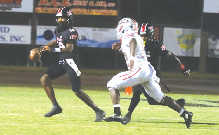 Fort White quarterback Chance Johnson rolls out to avoid pressure from Santa Fe last Friday. (MORGAN MCMULLEN/Lake City Reporter)