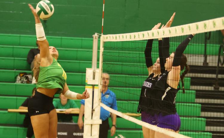 Suwannee hitter Calinn Daniel fires a shot while Columbia hitters Brynn Lester (1) and Langsley Smithy defend on Wednesday. (PAUL BUCHANAN/Lake City Reporter)