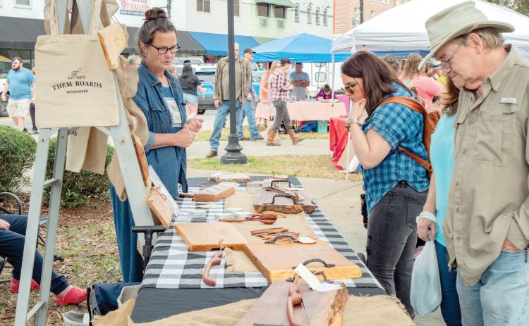 Woodwork from ‘Them Boards’ is viewed by some shoppers at a previous Lake City Growers and Makers Market. (COURTESY)