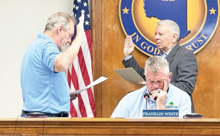 Roger Busscher (left) takes the oath of office to serve on the North Florida Water Utilities Authority board during its meeting Monday. NFWUA Attorney Grady Williams (right) administers the oath. (JAMIE WACHTER/Lake City Reporter)