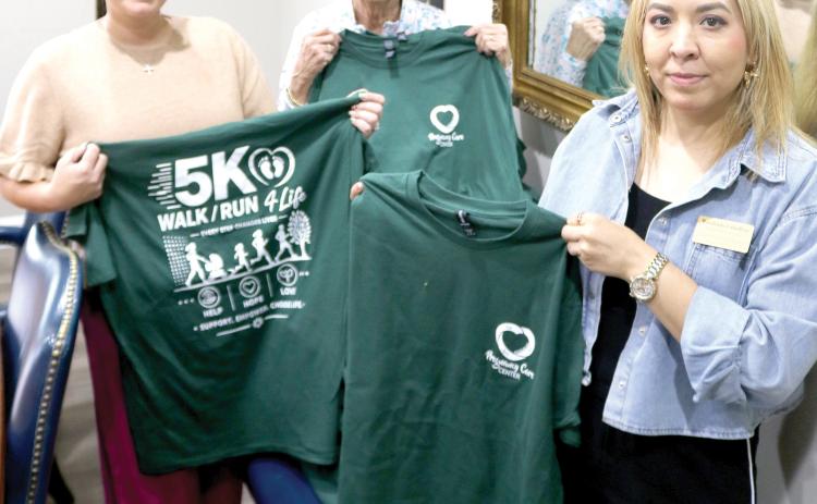 Lake City Pregnancy Care Center staff members Brittany Schied (from left), Charlene Brown and Rosalindo Caballero display T-shirts for the upcoming Pregnancy Care Center 5K Walk/Run 4 Life. (TONY BRITT/Lake City Reporter)