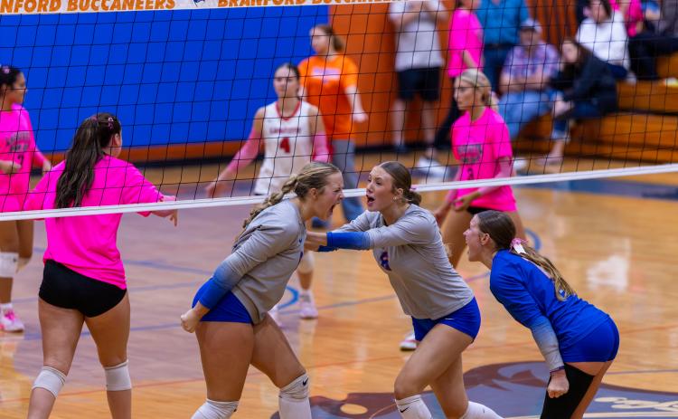 Branford outside hiitter Anabella Dicks (left) celebrates her kill with teammates Raelea Bradow (6) and Ava Alcorn (12) during Tuesday's win over Lafayette. (JACK HOWDESHELL/Lake City Reporter)
