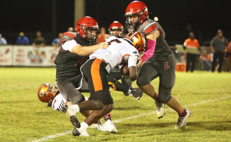 Lafayette linebacker Trevor Byrd tackles Trenton running back Kevone Markham as defensive back Jackson Lawson rushes in on Oct. 16. (PAUL BUCHANAN/Lake City Reporter)