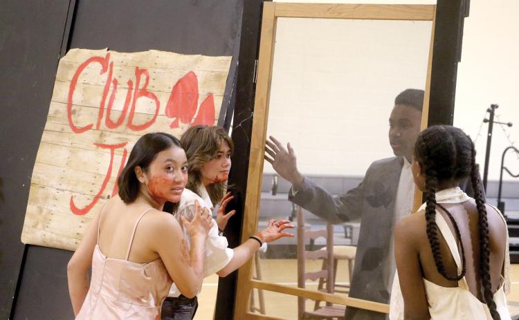 Angel Le (from left) and Charli Hughes hunt Chip Gordon as vampires as they recreate a scene from the movie ‘Sinners’ for the 12th annual CHS Theatre Haunted House. (MORGAN MCMULLEN/Lake City Reporter)
