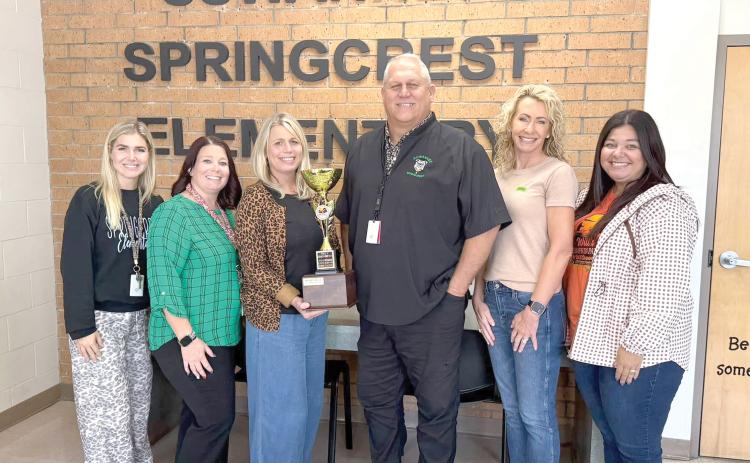 Suwannee Springcrest Elementary Principal Jennifer Beach holds the Will’s Golden Spirit Cup trophy after the school won the challenge from the Will Carpenter AYA Cancer Foundation for Childhood Cancer Awareness Month in September. Beach is joined by other school staff members as well as Ashleigh Pitzer, the founder of the foundation (second from right), and Charis Parker with the foundation (right). (COURTESY)