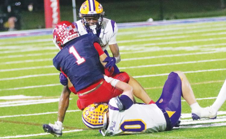 Columbia defensive back Mekah Combs-Turner (back) and linebacker Bryson Grinstead (bottom) combine to tackle Manatee receiver Deno Dalacas on Oct. 2. (JORDAN KROEGER/Lake City Reporter)