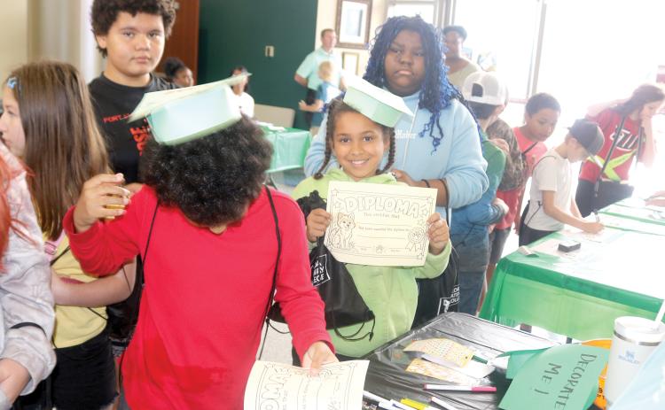 Fort White Elementary School fifth-graders created graduation caps and diplomas while attending an event at the college on Friday morning. (TONY BRITT/Lake City Reporter)