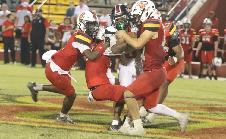 Fort White receiver Jakori Johnson gets tackled by a host of Baker County defenders following a catch on Friday. (MORGAN MCMULLEN/Lake City Reporter)