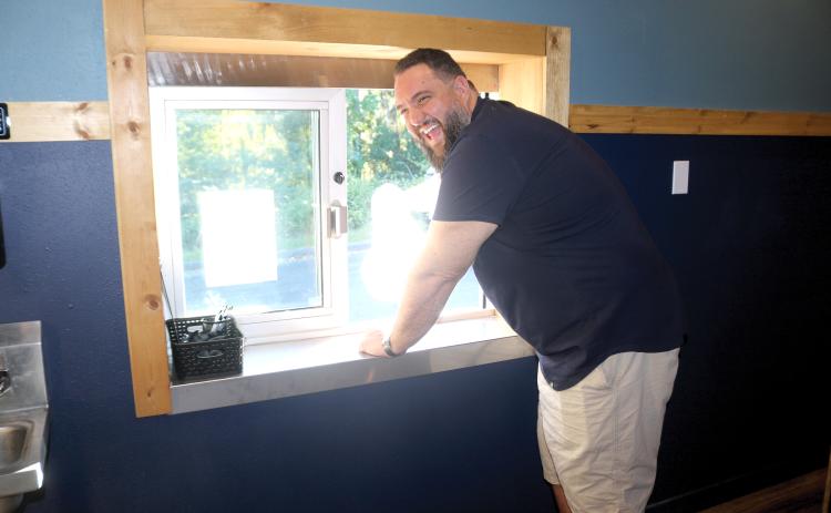 James Crenshaw, proprietor of Phish Tales, laughs as he hands out a meal through the restaurant’s new drive-through window. The restaurant also is adding a cocktail lounge, an inside waiting area and offering up additional dessert options from Amy Strickland. (TONY BRITT/Lake City Reporter)