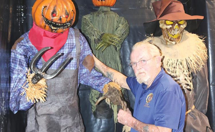 American Legion Post 57 Commander Bill Huggins shows off some of the characters that will greet children for a Kids Safe Halloween event on Saturday. (TONY BRITT/Lake City Reporter)