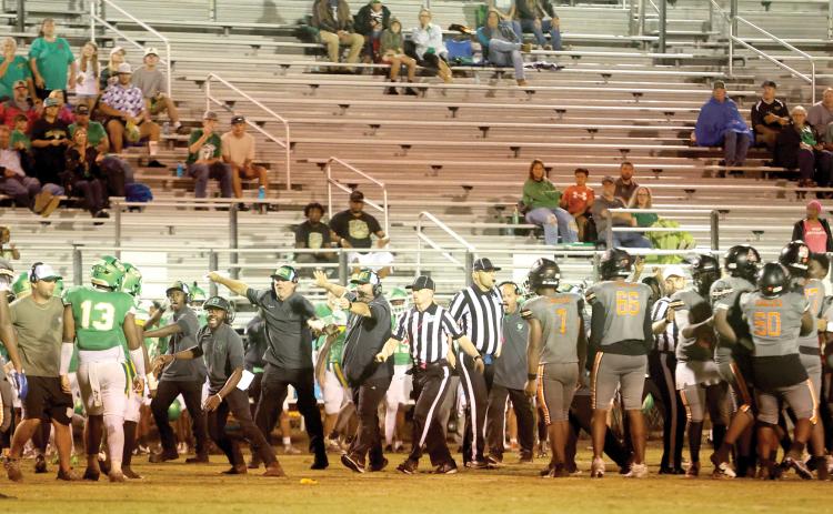 Suwannee head coach Kyler Hall and assistants PJ Davis, Kendrick Carter and Brian Wilder try to get the Bulldogs, including Jadayce Jones (13) to get away after a skirmish broke out late in the third quarter Friday against Zarephath Academy. Officials try to keep the Zarephath players separated. The game ended moments later when the Eagles decided to quit after having one player previously ejected as well. (PAUL BUCHANAN/Lake City Reporter)