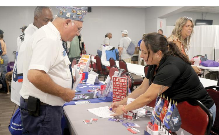 Megan Douglas (right), a representative of The Fire Watch, talks to a veteran during the Veteran Stand Down and Resource Fair at the American Legion Post 57 on Wednesday. (TONY BRITT/Lake City Reporter)