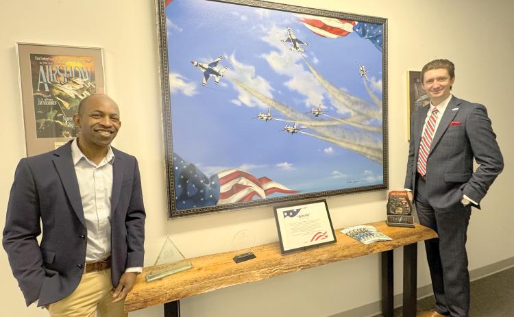 Pedro Jermaine, an internationally known artist and Lake City resident (left), is pictured with Columbia County Tourist Development Council Executive Director Cody Gray after loaning the Visit Lake City Welcome Center and TDC office his ‘BOOM’ painting that was created in honor of the 2016 Gateway to Florida Airshow. (JAMIE WACHTER/Lake City Reporter)