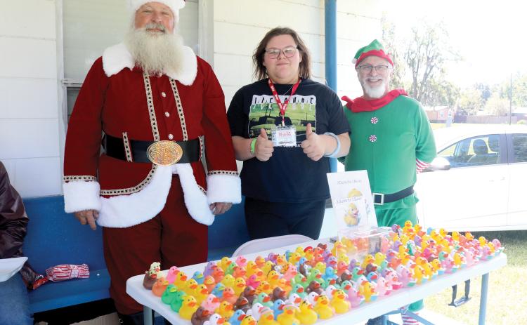 Mike Haney (from left), dressed as Saint Nicholas, stands with Linda Knox and Jim Senzamici during the inaugural charity biker’s ride for the Suwannee County Toys for Tots program. (TONY BRITT/Lake City Reporter)