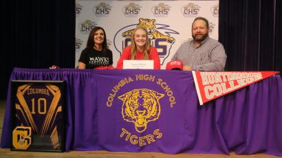 Columbia volleyball player Lauren Wilson (middle) signed her national letter of intent Monday to play at Huntingdon College in Montgomery, Ala. alongside her mother Michelle Wilson and her father Todd Wilson. (JORDAN KROEGER/Lake City Reporter)
