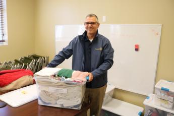 Mike Tatem, Parkview Baptist Church pastor, moves a container of towels and other toiletries on Thursday while preparing to open the church’s cold weather shelter. (TONY BRITT/Lake City Reporter)