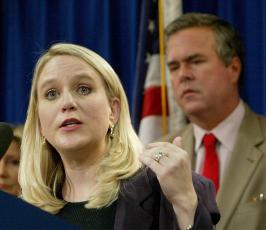 In this 2004 file  photo, Tiffany Carr, executive director of the Florida Coalition Against Domestic Violence, left, speaks at a news conference held by Gov. Jeb Bush, background right. (AP FILE PHOTO)