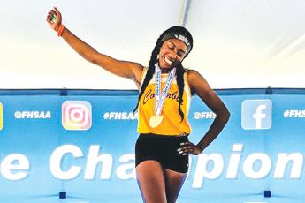 Columbia jumper Asherah Collins celebrates on the podium with her gold medal after winning the Class 3A state title in the triple jump last May at Hodges Stadium at UNF. (FILE)