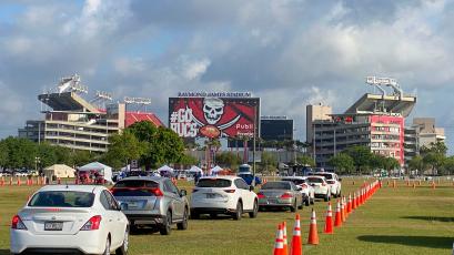 Cars are lined up in the parking lot outside of Raymond James Stadium for coronavirus testing on March 25, in Tampa. (LUIS SANTANA/Tampa Bay Times/TNS)