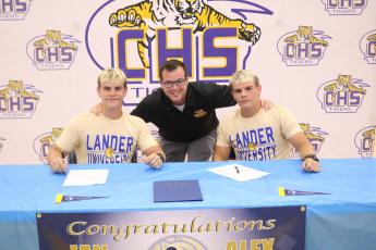 Columbia wrestlers Ian McGuigan (left) and Alex McGuigan (right) are pictured with head coach Pete Whittington (middle) after they signed their letters of intent with Lander on Thursday. (JORDAN KROEGER/Lake City Reporter)