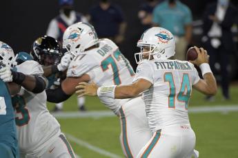 Miami Dolphins quarterback Ryan Fitzpatrick (14) throws a touchdown pass against the Jacksonville Jaguars during the first half Thursday, in Jacksonville. (PHELAN M. EBENHACK/Associated Press)