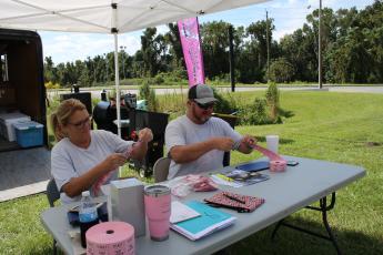 Sherry Wheeler Sheppard (left) and Donnie Feagle (right), Suwannee River Breast Cancer Awareness Association president, sell raffle tickets for the upcoming Suwannee River Breast Cancer Awareness Open Bass Tournament. The tournament will take place this Saturday at Sandy Point boat ramp in Branford. The event’s weigh-in is scheduled for 3 p.m. (TONY BRITT/Lake City Reporter)