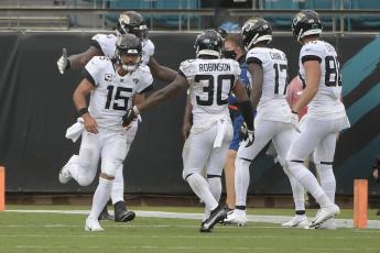 Jacksonville Jaguars quarterback Gardner Minshew (15) celebrates after throwing a touchdown pass to wide receiver D.J. Chark (17) during the first half of an NFL football game against the Indianapolis Colts on Sunday, in Jacksonville. (AP PHOTO)