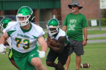 Suwannee quarterback Jaquez Moore follows a block during practice in August. (FILE)