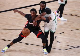 Boston Celtics forward Jaylen Brown (7) and Miami Heat center Bam Adebayo (13)  fight for a loose ball during the fourth quarter in Game 6 of the Eastern Conference finals at AdventHealth Arena at the ESPN Wide World Of Sports Complex on Sunday, in Lake Buena Vista. (KEVIN C. COX/Getty Images/TNS)
