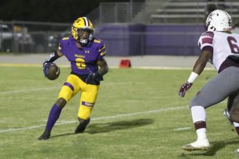 Columbia receiver Tray Tolliver scrambles out of the wildcat package against Madison County last Friday. (BRENT KUYKENDALL/Lake City Reporter)