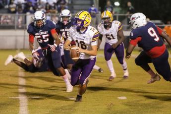 Columbia quarterback Bronsen Tillotson rolls out to pass last Friday against Wakulla. (BRENT KUYKENDALL/Lake City Reporter)