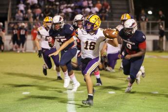 Columbia quarterback Bronsen Tillotson rolls out to pass against Wakulla on Friday night. (BRENT KUYKENDALL/Lake City Reporter)