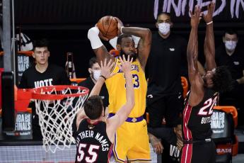 Los Angeles Lakers forward LeBron James passes between Miami Heat guard Duncan Robinson, left, and forward Jimmy Butler during the second half in Game 4 of the NBA Finals on Tuesday in Lake Buena Vista. (JOHN RAOUX/Associated Press)