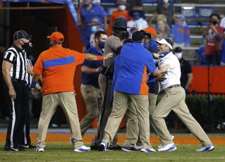 Florida coach Dan Mullen, right, is held back by coaches and law enforcement after a fight broke out at the end of the first half of Saturday's game against Missouri in Gainesville. (BRAD MCLENNY/The Gainesville Sun via AP)
