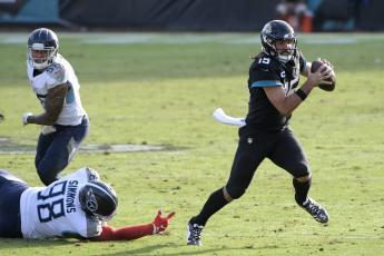 Jacksonville Jaguars quarterback Gardner Minshew II (15) scrambles away from Tennessee Titans defensive tackle Jeffery Simmons (98) on Sunday in Jacksonville. (PHELAN M. EBENHACK/Associated Press)