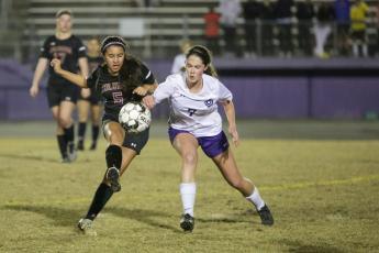Columbia’s Carla Medina fights for possession of the ball with Gainesville’s Zoe Lammers on Thursday night. (BRENT KUYKENDALL/Lake City Reporter)