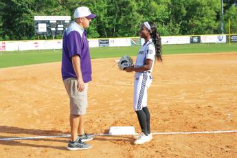 Columbia pitcher Cris’Deona Beasley laughs with assistant coach Mitch Shoup prior to the team’s game against Baker County on Apr. 12. (BRENT KUYKENDALL/Lake City Reporter)