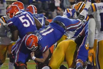 Florida quarterback Kyle Trask (11) dives over the LSU defense for a 1-yard touchdown on Saturday in Gainesville. (JOHN RAOUX/Associated Press)