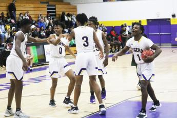 Columbia teammates help Dante Brown (0) off of the floor and celebrate after Brown made a layup while getting fouled by Suwannee on Friday night. (JORDAN KROEGER/Lake City Reporter)