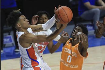 Florida guard Tre Mann (1) and Tennessee guard Davonte Gaines (0) compete for a rebound on Tuesday in Gainesville. (MATT STAMEY/Associated Press)