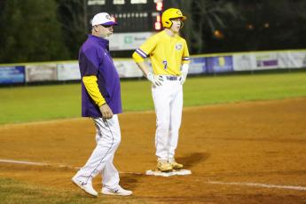 Columbia outfielder Kade Jackson stands on third base alongside coach Brian Thomas during Friday night’s game against Baker County. (BRENT KUYKENDALL/Lake City Reporter)